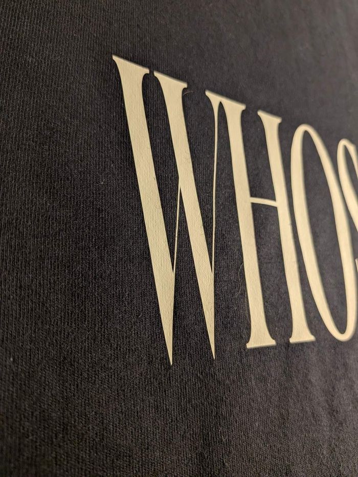 Close-up of the pressed lettering, showing the cut edge of the vinyl sitting on top of the cotton weave.
