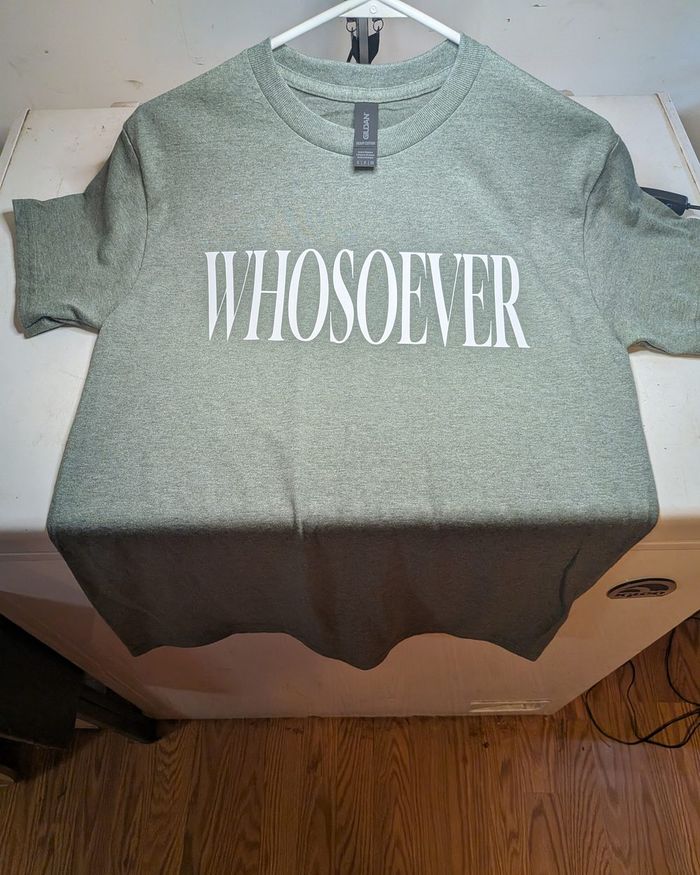 A green WHOSOEVER T-shirt laid out flat.